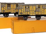 deux wagons de train miniature posés sur une boîte jaune