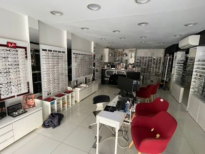 many glasses on display in a store with red chairs