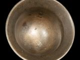 a metal bowl that is sitting on a black surface