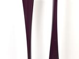 pair of tall purple glass vases sitting next to each other on a white surface