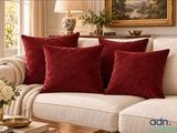 three red pillows on a white couch in a living room