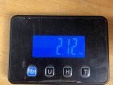 a digital clock on a table with a charger