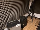 a room with a bunch of speakers and a guitar on the floor