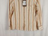 a white shirt with orange and green stripes is hanging on a hanger