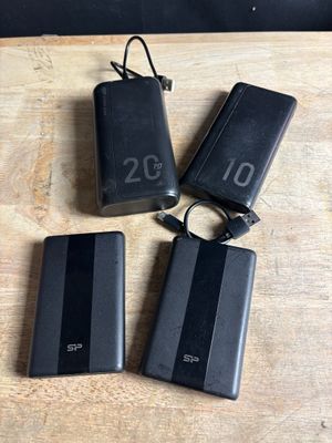 three black power banks sitting on top of a wooden table