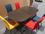 a table with four chairs around it on the sidewalk