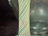 a green and white striped vase sitting next to a green vase