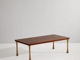 une table basse avec des pieds en laiton et un plateau en bois