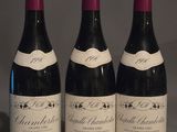 trois bouteilles de vin posées sur une table l'une à côté de l'autre