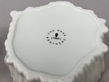 a small white bowl with a black design on it