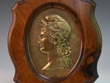 une photo d'une plaque en bronze représentant une femme coiffée d'une couronne