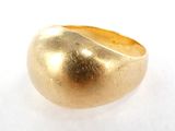 une image représentant une bague en or posée sur une surface blanche
