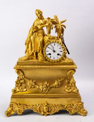 une horloge en or surmontée d'une statue