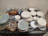 many plates and bowls sitting on a table covered in plastic wrap