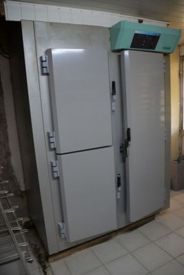 a refrigerator in a kitchen with a lot of clutter on the floor