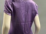an image of a mannequin wearing a purple shirt and beige pants