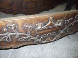 a wooden bed with a carved design on the headboard