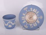 une horloge bleue et blanche et une tasse posées sur une table