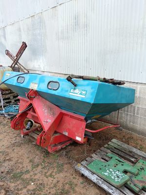 a blue and red boat sitting on the ground next to a pallet