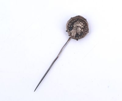 une image représentant une broche en argent sur laquelle est posée une pièce de monnaie, sur un fond blanc