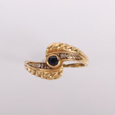 gros plan d'une bague en or avec une pierre en saphir