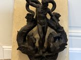 statue of a man holding a snake on a marble block