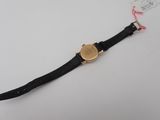 a close up of a watch on a white surface with a tag on it