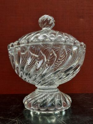 un saladier en verre avec un couvercle posé sur une table