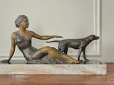 une statue représentant une femme et un chien assis sur une table