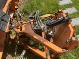 a tractor that is sitting in the grass on the side of the road