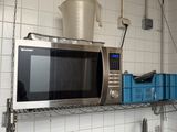 a microwave that is sitting on a shelf in a kitchen