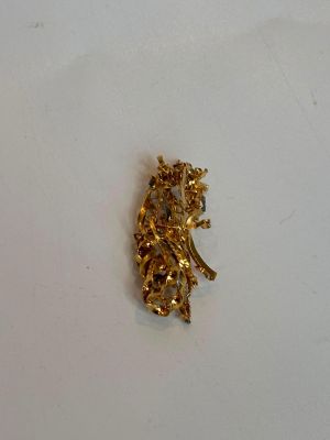 une broche en or sur un fond blanc