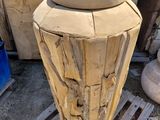 a large vase made out of wood sitting on a pallet
