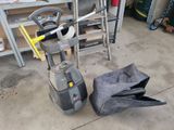 un aspirateur posé par terre à côté d'un sac