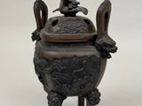 chinese bronze incense burner with a seated figure on top of it