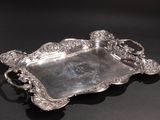 an antique silver tray with handles and handles on a black surface