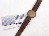 bracelet en cuir marron sur une montre à laquelle est attachée une étiquette