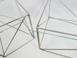 pair of metal and glass geometric tables on a white background