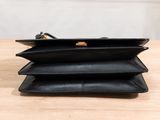 a black purse sitting on top of a wooden table