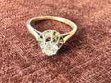 un gros plan d'une bague en diamant posée sur un tissu marron