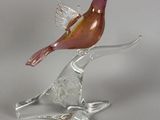 un oiseau en verre perché sur une branche