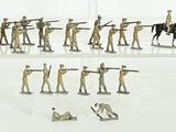 many figurines of soldiers on display on a white surface