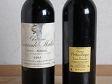 two bottles of wine sitting on a table next to each other