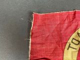 an old red and yellow flag with a banana hanging from it ' s side