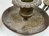 a metal candle holder with a flower design on it