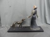 statue of a woman and a dog on a black base