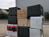 a stack of appliances on a pallet in front of a building