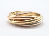 gros plan d'une bague en or et en argent sur une surface blanche