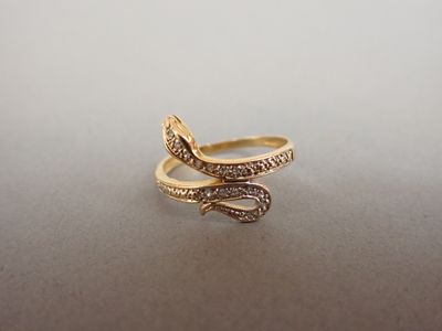 une photo d'une bague en or en forme de serpent, sertie de diamants