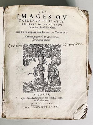 an old book sitting on top of a table next to a white wall